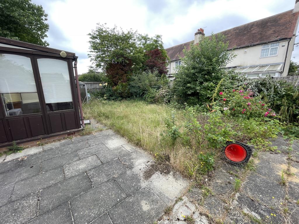Lot: 99 - DETACHED BUNGALOW WITH CONSERVATORY FOR IMPROVEMENT - External view of rear garden and conservatory